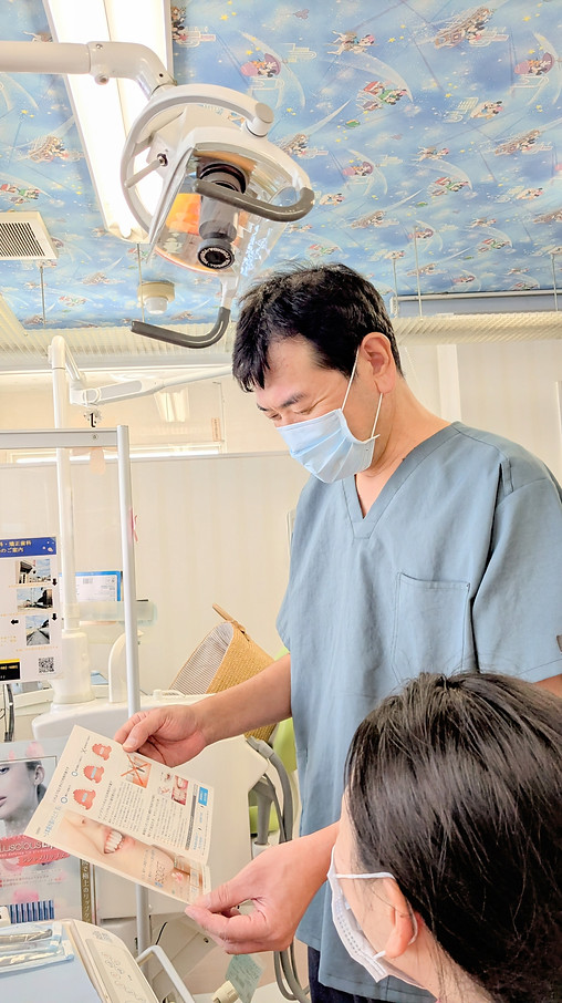 院長が資料を見せながら患者に説明する様子