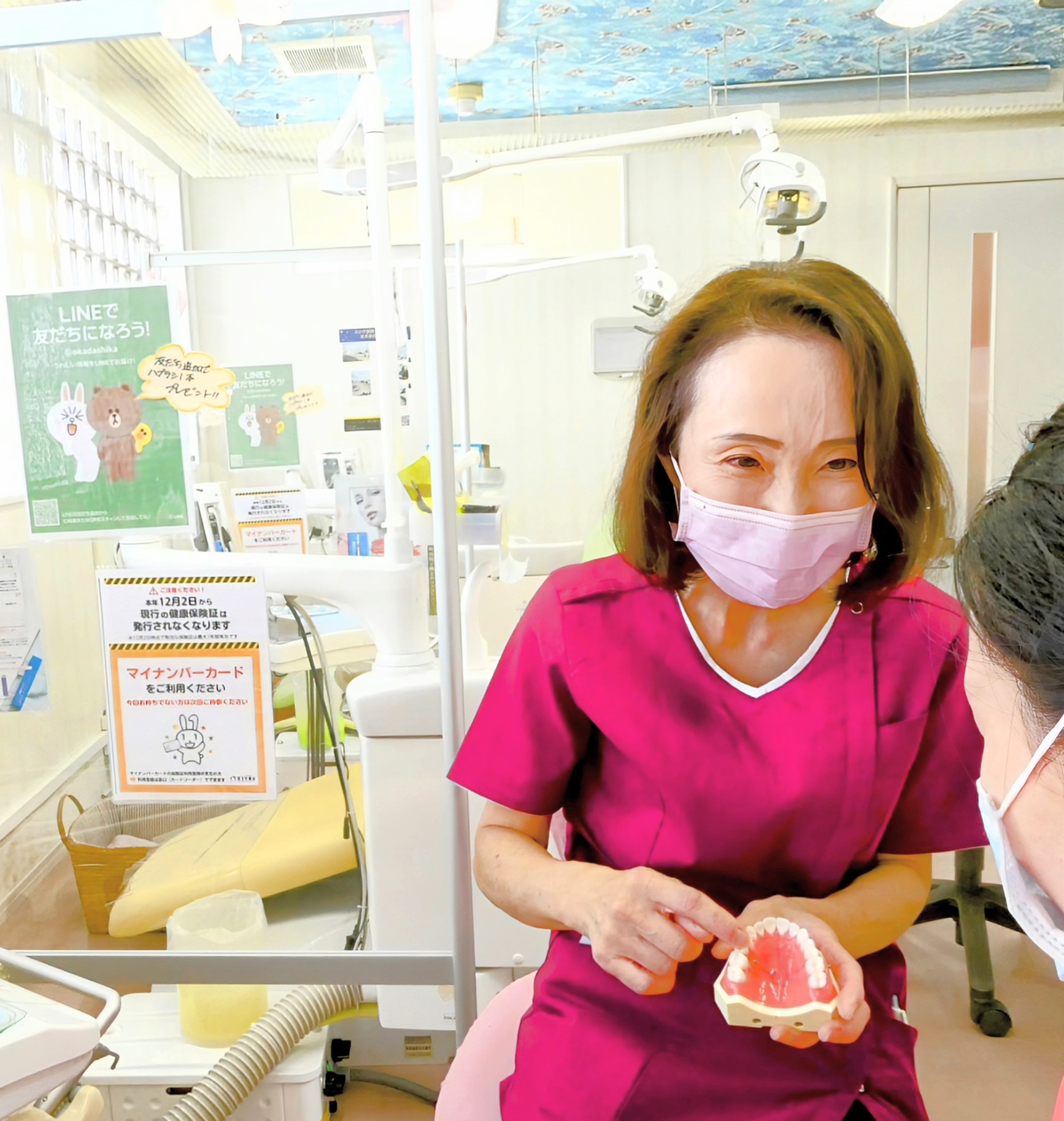小児歯科診療で歯科模型を使い説明する女性歯科医師
